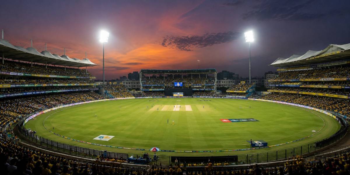 MA Chidambaram Stadium panoramic view with the cricket pitch, packed stands, floodlights, and evening sky.